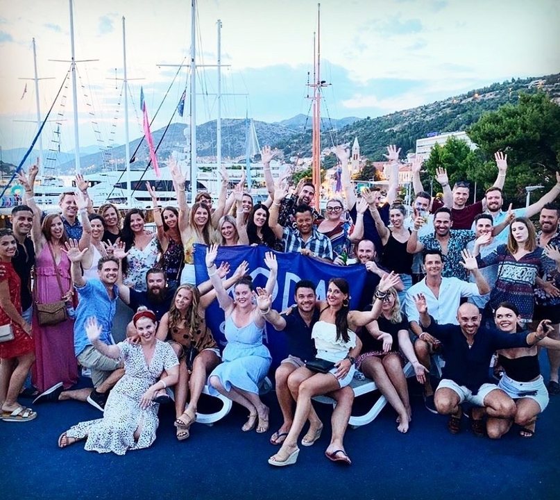 Grand groupe de personnes posant ensemble à l'extérieur.