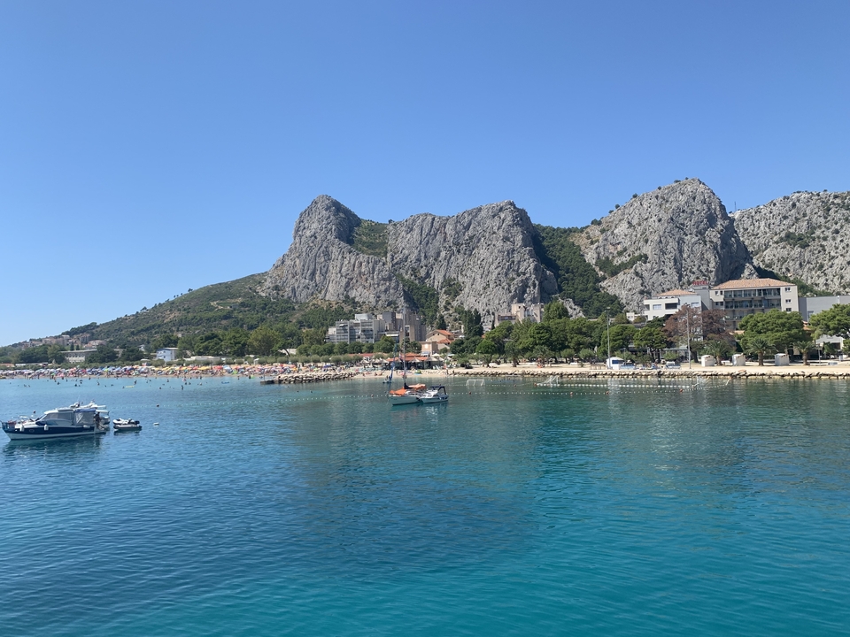 Vue d'une ville côtière avec des montagnes en arrière-plan.