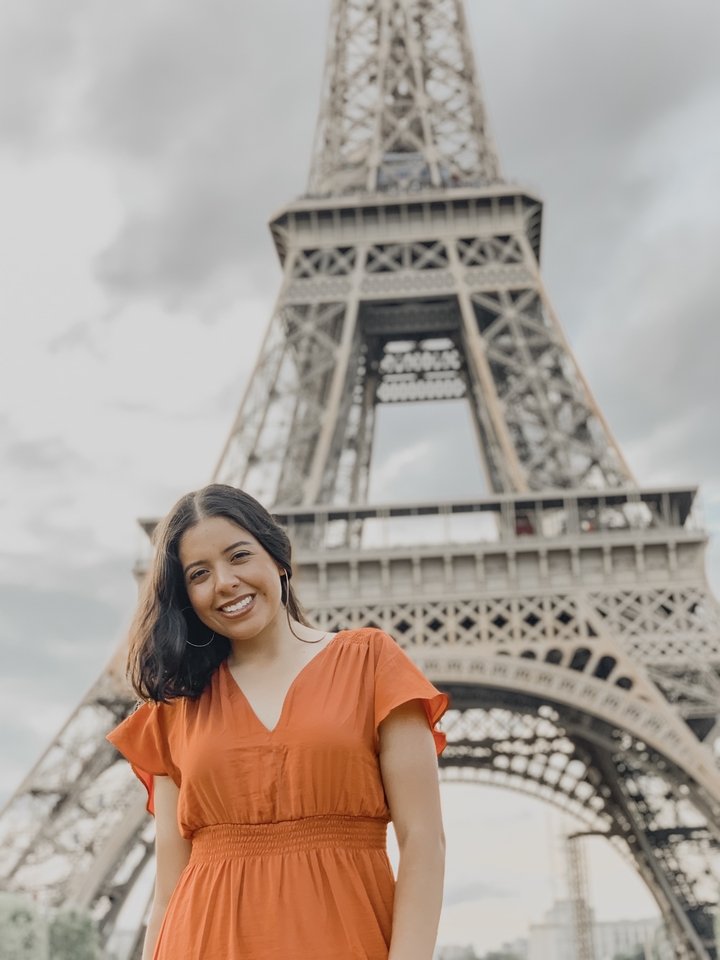 Personne souriante avec la tour Eiffel en arrière-plan.