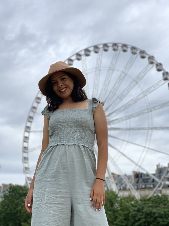 Personne souriante devant une grande roue.