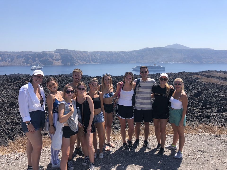 Groupe de personnes sur une colline avec un navire de croisière en arrière-plan.
