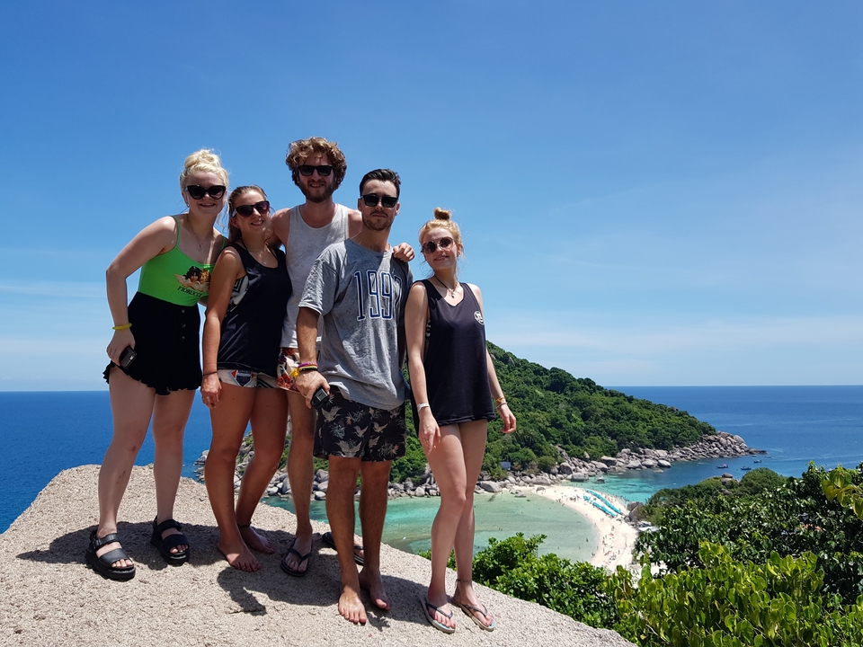 Friends on a hill with scenic views of the ocean.
