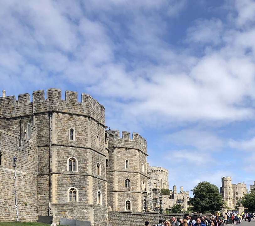 Gros plan d'une tour de château en pierre avec un ciel bleu.