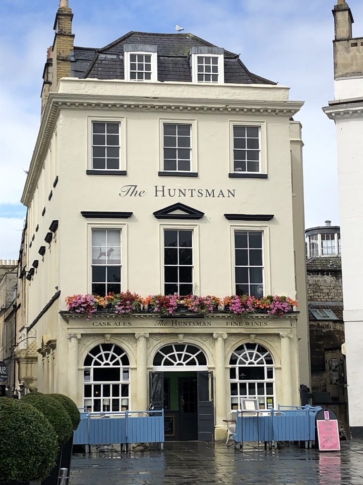 Façade du pub 'The Huntsman' avec des jardinières.
