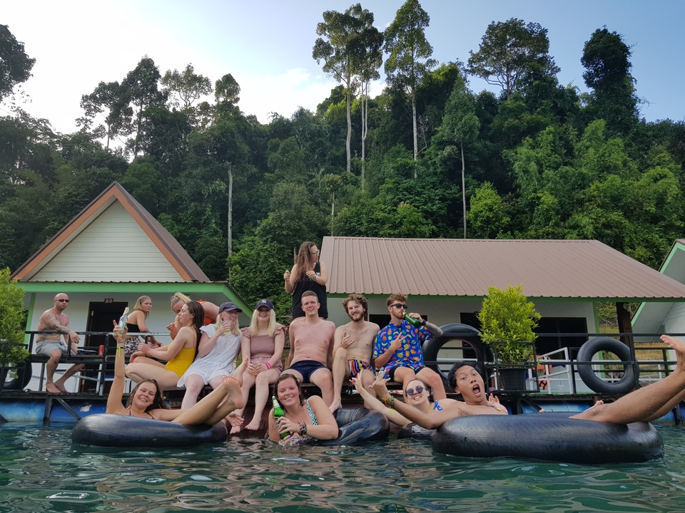 Groupe assis sur un quai flottant près d'un lac en forêt.
