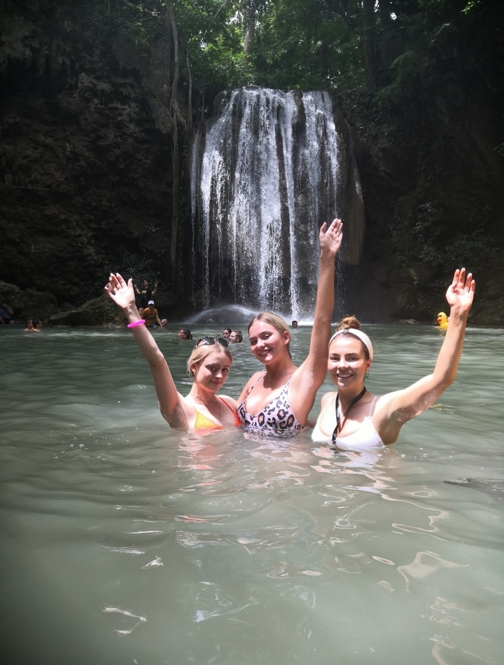 Des gens profitant d'une cascade avec un focus sur trois femmes au premier plan