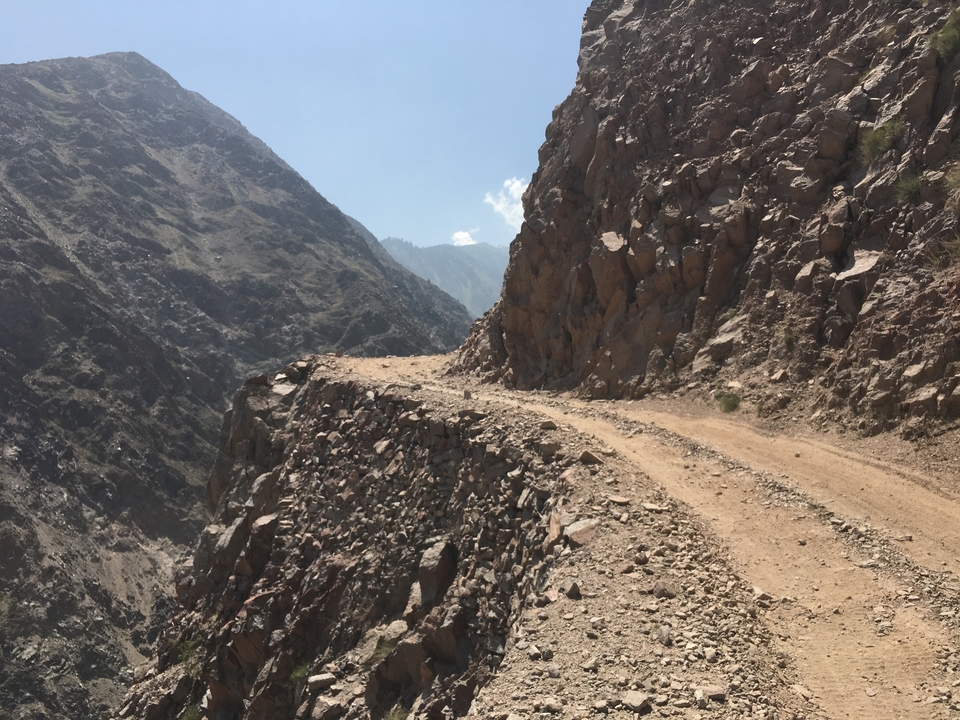 Une route de montagne accidentée avec des falaises rocheuses abruptes.