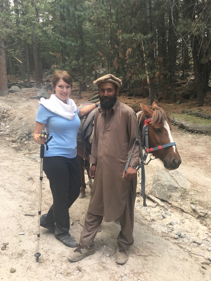 Deux personnes posant avec un cheval sur un sentier.