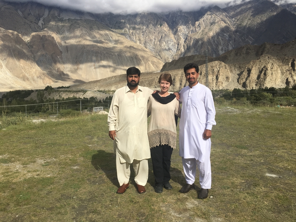Trois personnes posant avec des montagnes en arrière-plan.