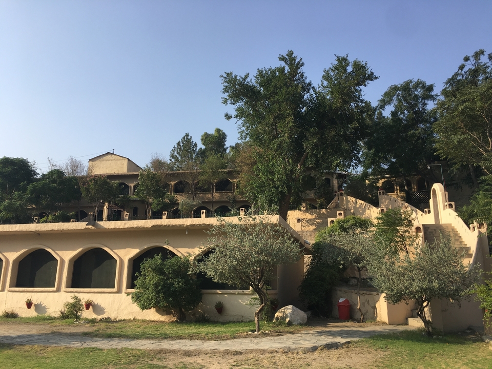 Un complexe de bâtiments situé sur une colline avec des arbres.