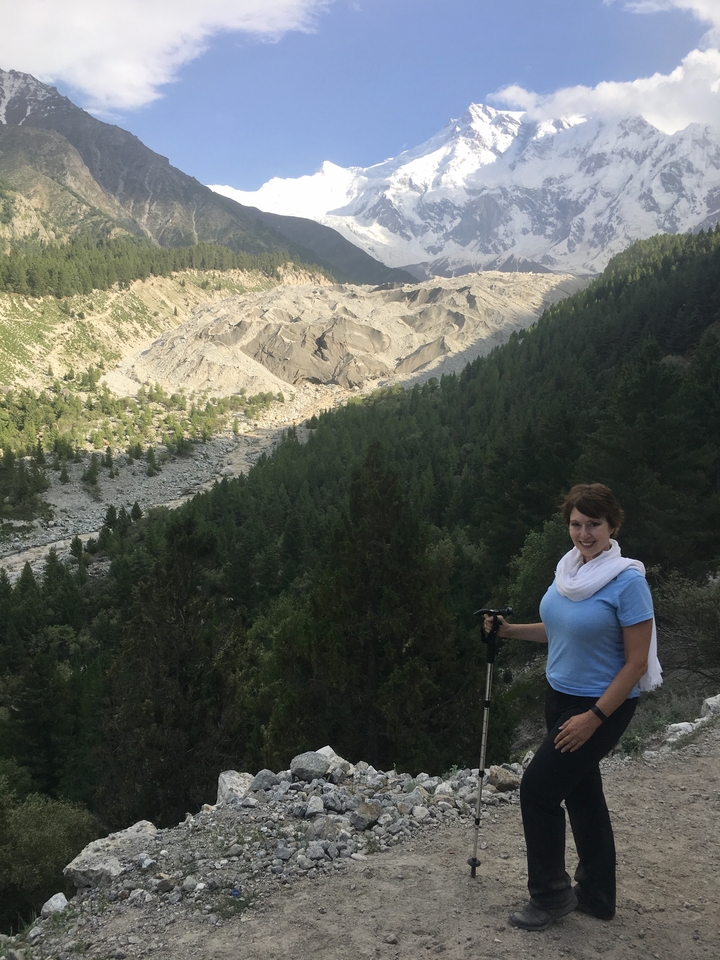 Une femme faisant de la randonnée avec vue sur une vallée rocheuse et une forêt en arrière-plan.
