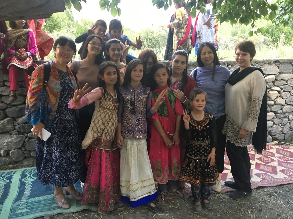 Un groupe de femmes et d'enfants en tenues traditionnelles qui posent pour une photo.