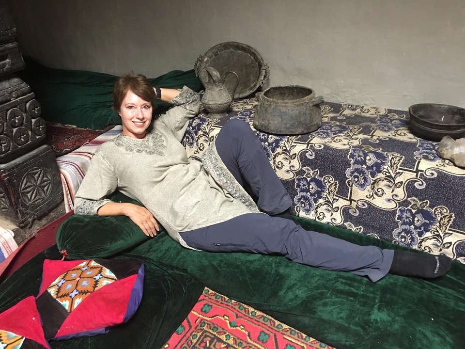 Une femme qui se détend sur un tapis traditionnel avec une décoration traditionnelle.
