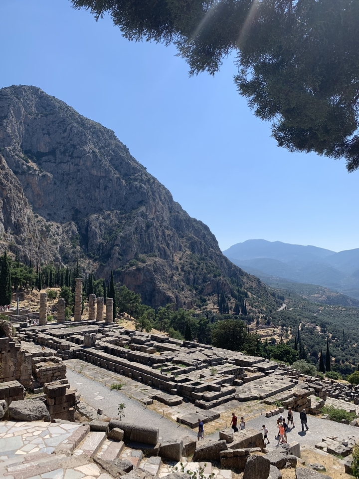 Ruines d'un temple antique parmi les montagnes et les arbres.