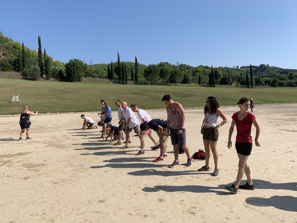Groupe de personnes se préparant pour une course sur une piste sablonneuse.