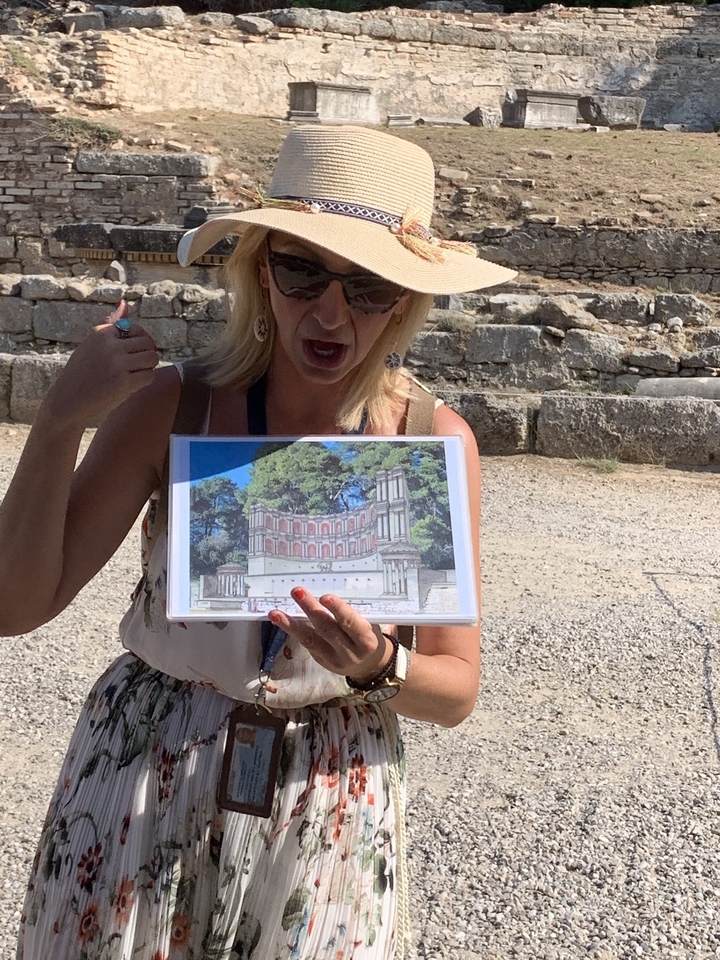 Femme tenant une illustration historique sur un site archéologique.