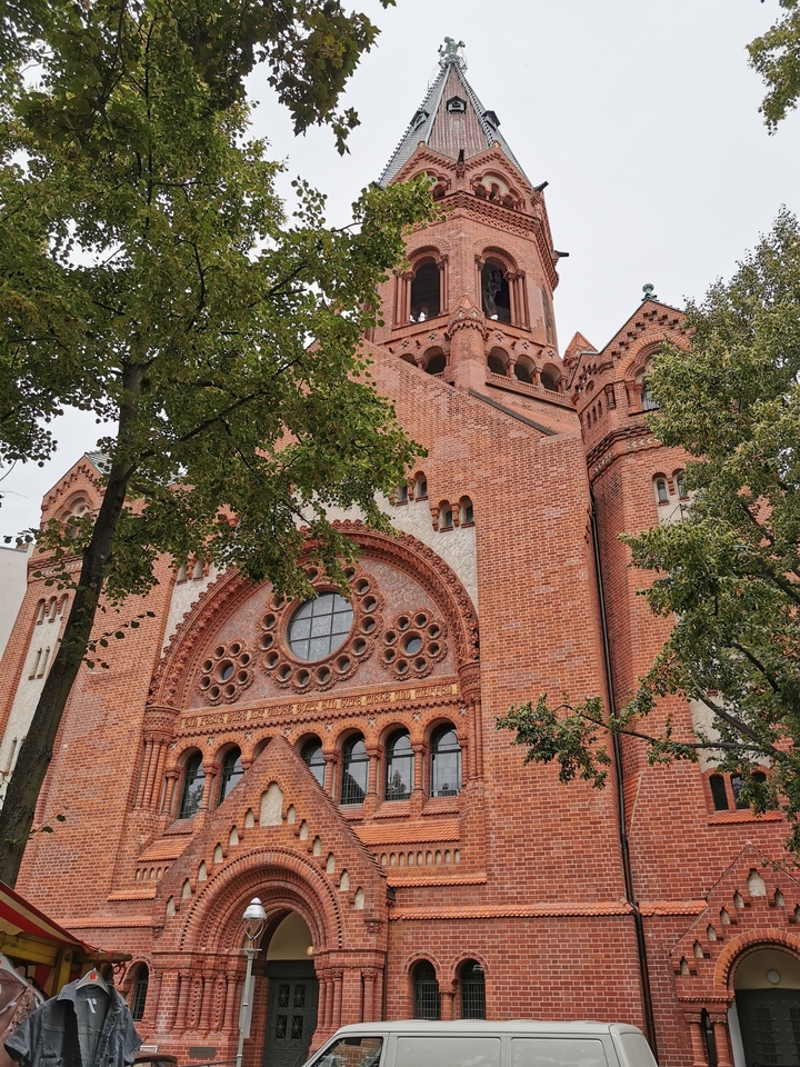 Une église en brique ornée avec une rosace.