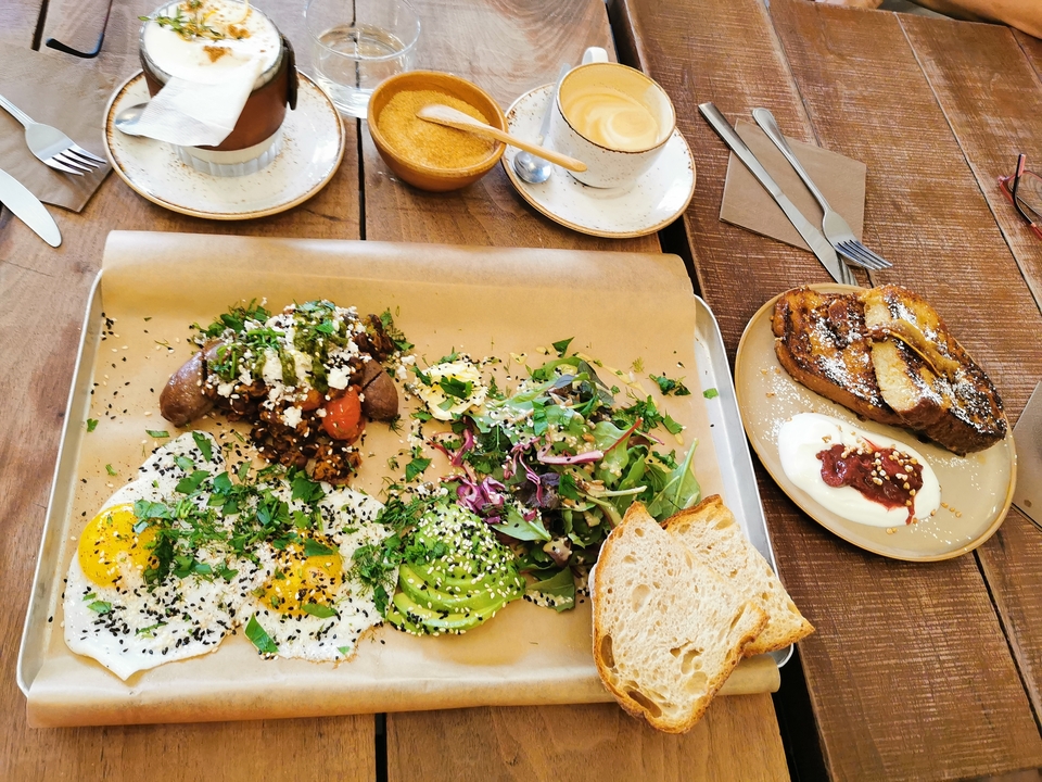 Table de brunch avec divers plats incluant des œufs et des toasts.