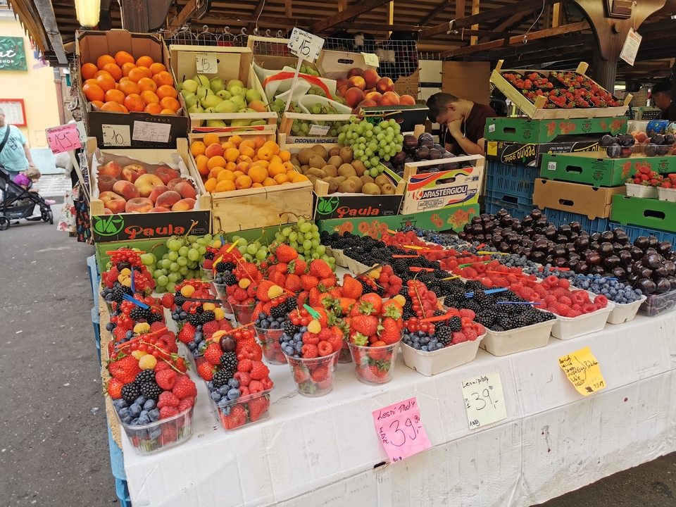 Étalage de marché avec des fruits et des baies colorés.