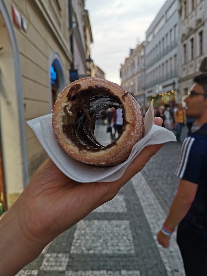 Une main tenant une pâtisserie fourrée au chocolat.