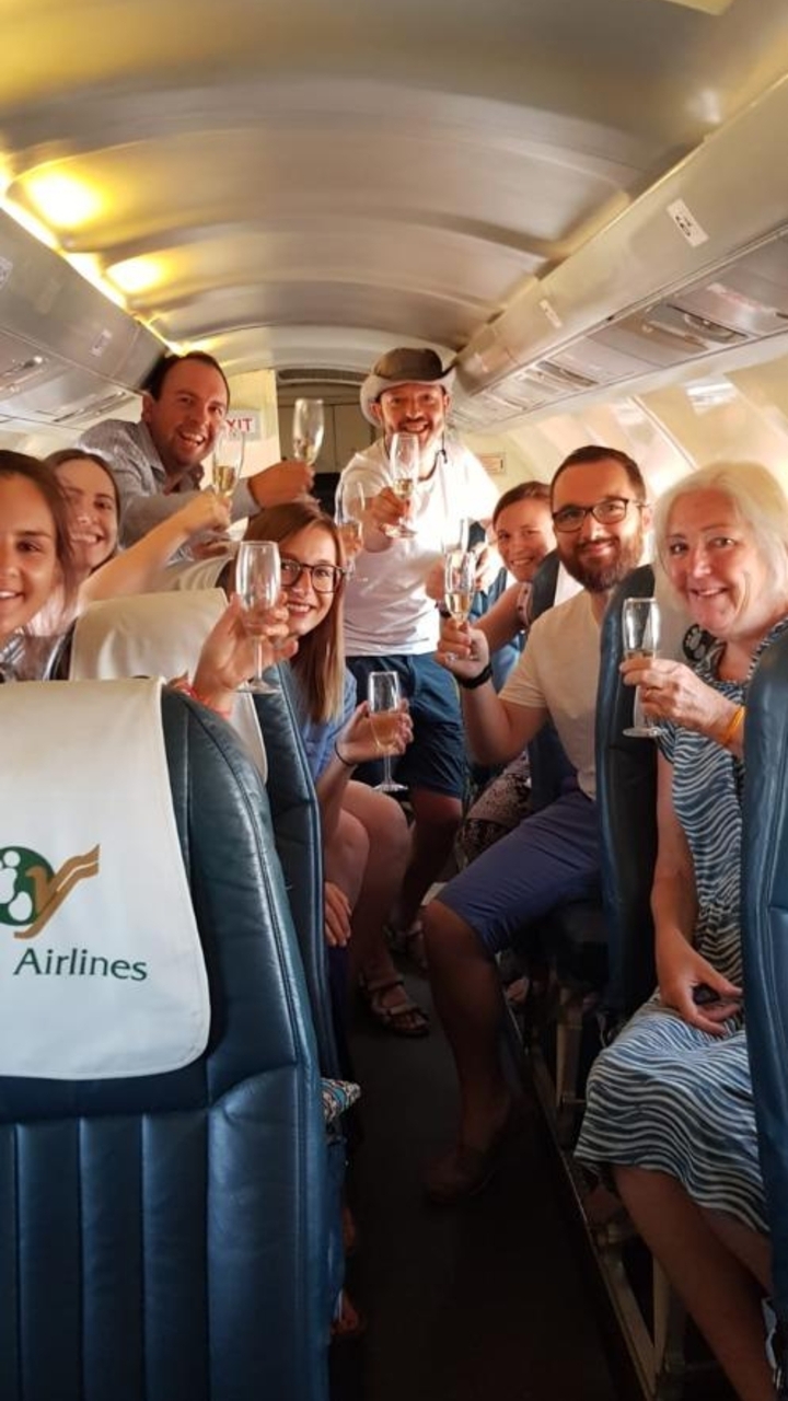 Groupe de personnes trinquant avec des boissons à l'intérieur d'un véhicule.