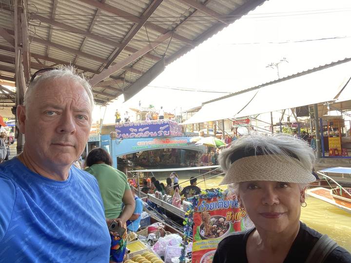 Des gens sur un marché flottant avec des bateaux et des étals.