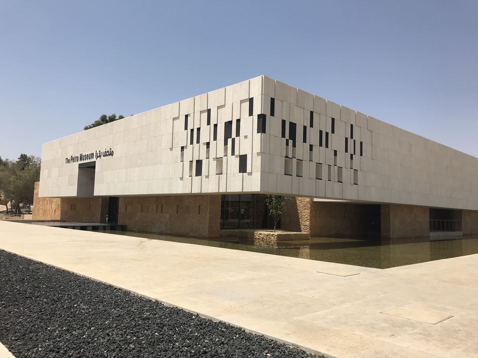 Bâtiment moderne au design géométrique dans un paysage aride.