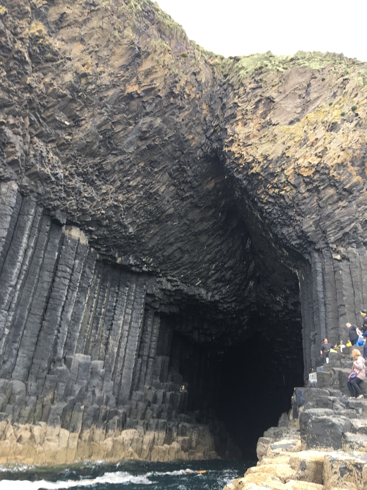 Gros plan de colonnes de basalte à l'entrée d'une grande grotte.