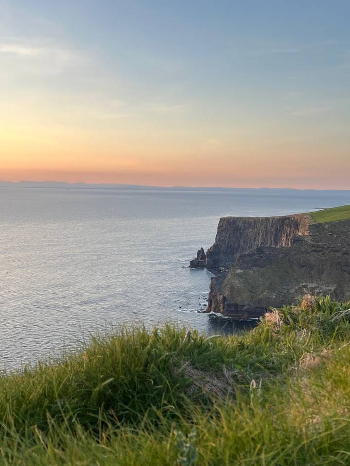 Vue du coucher de soleil sur les falaises et l'océan.