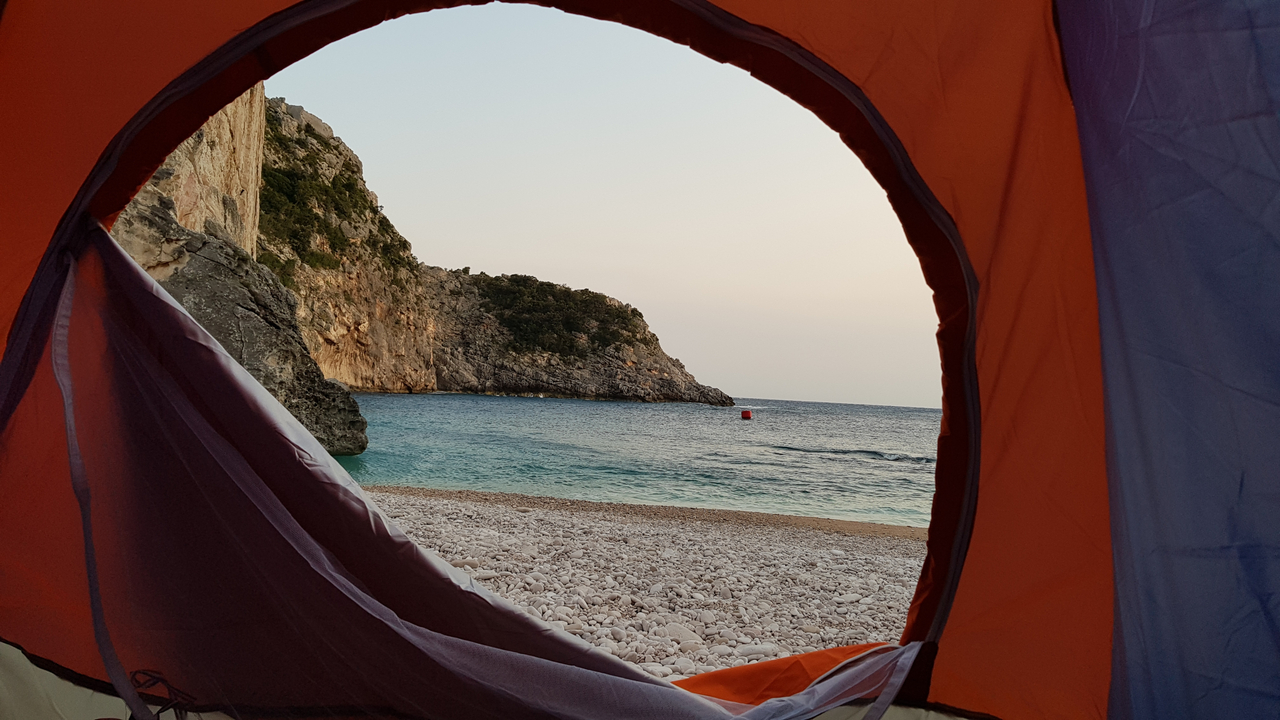 Vue sur le bord de mer depuis l'intérieur d'une tente avec vue sur l'océan.