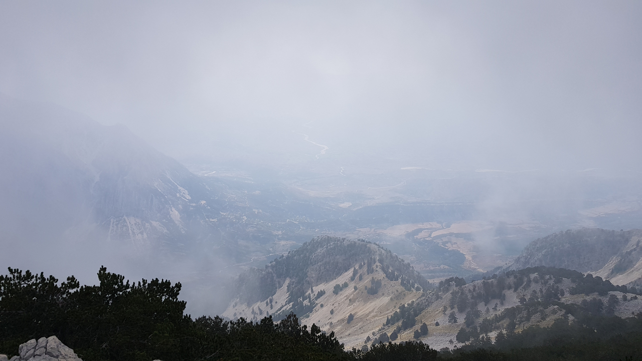 Un paysage montagneux brumeux avec une visibilité limitée.