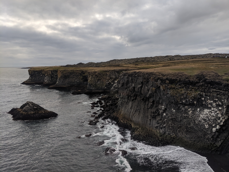 Coastal cliffs with exposed rock faces and seawater.