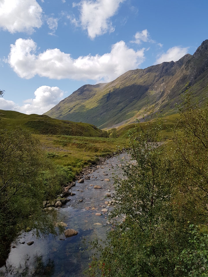 Mountain valley scene with a stream flowing through.