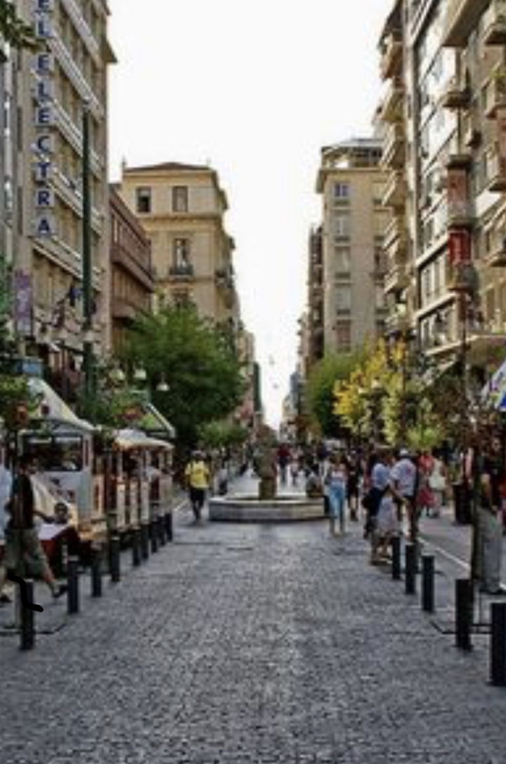 Image floue d'une rue de ville animée avec des gens qui marchent.