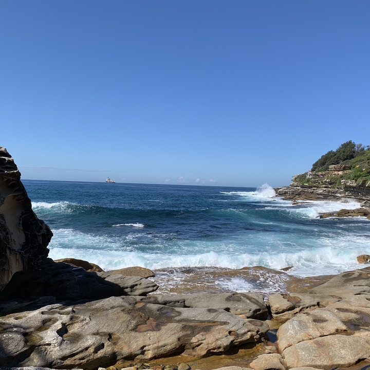 Des vagues qui se brisent contre un rivage rocheux.