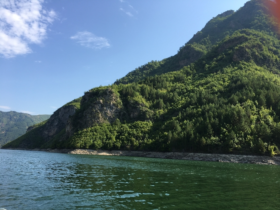 Vue panoramique d'une montagne verdoyante et d'une rivière.