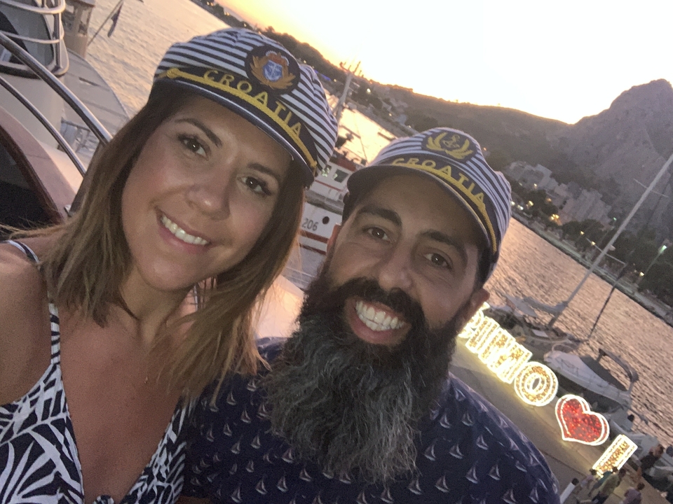 Gros plan d'un couple portant des chapeaux aux couleurs de la Croatie sur un bateau.