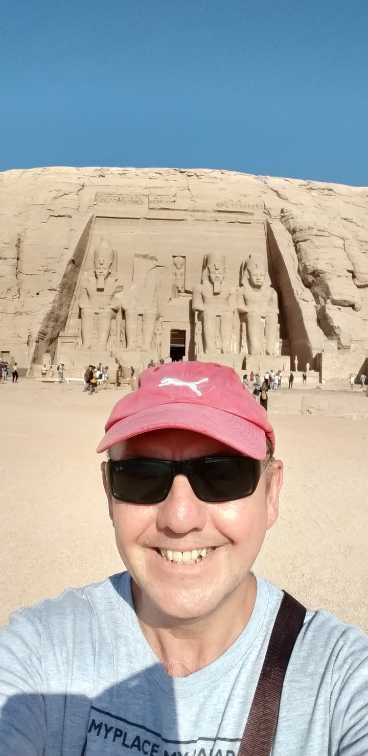 Person in front of the Abu Simbel temple facade.