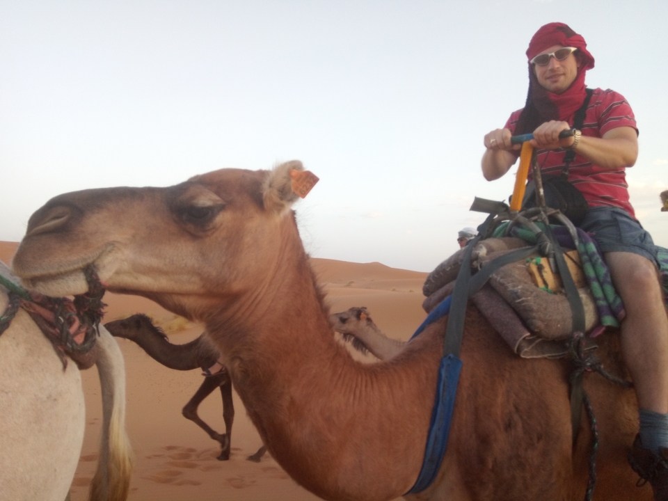 Personne montant un chameau dans le désert.