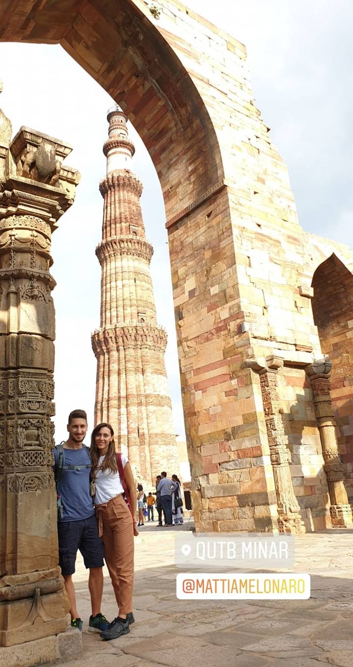 Des personnes posant devant le complexe du Qutub Minar.