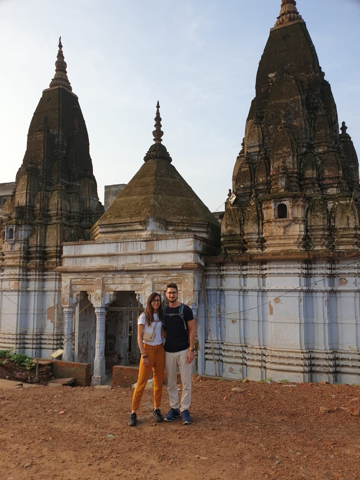 Deux personnes debout devant une architecture de temple ancien.