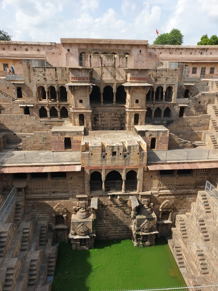 Structure ancienne de puits à degrés en pierre avec une architecture complexe.