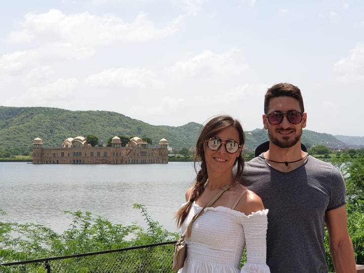 Couple posant devant le Jal Mahal sur un lac.