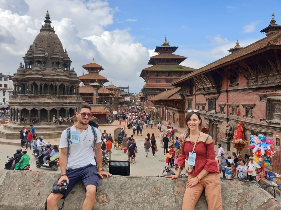 Des gens explorant une place de ville historique animée.