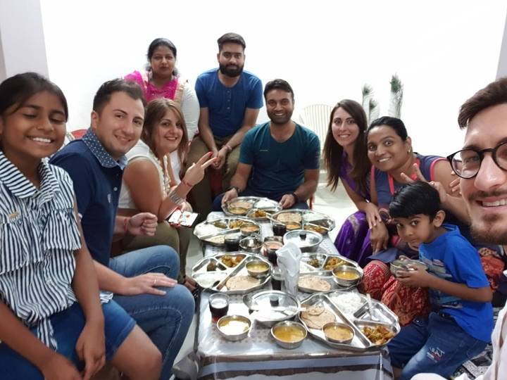 Famille rassemblée autour d'une table avec un repas traditionnel indien.