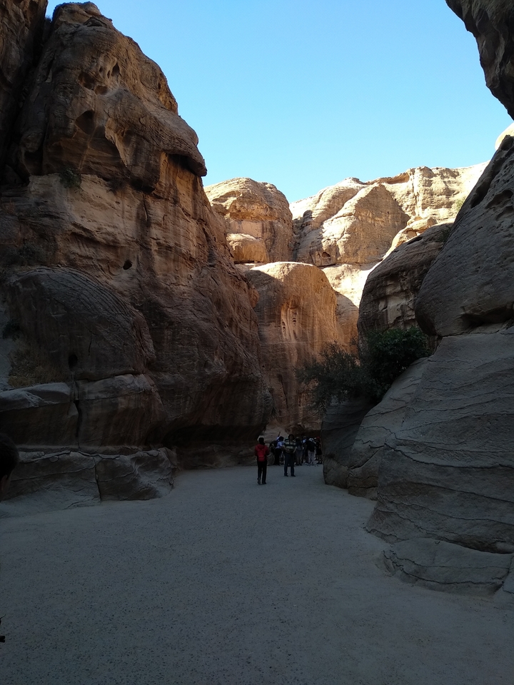 Des gens qui marchent à travers les parois étroites du canyon à Pétra.
