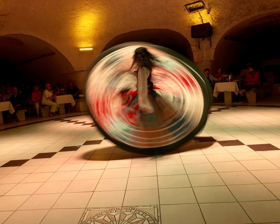 Mouvement flou d'une danseuse qui tourne en costume aux couleurs vives.