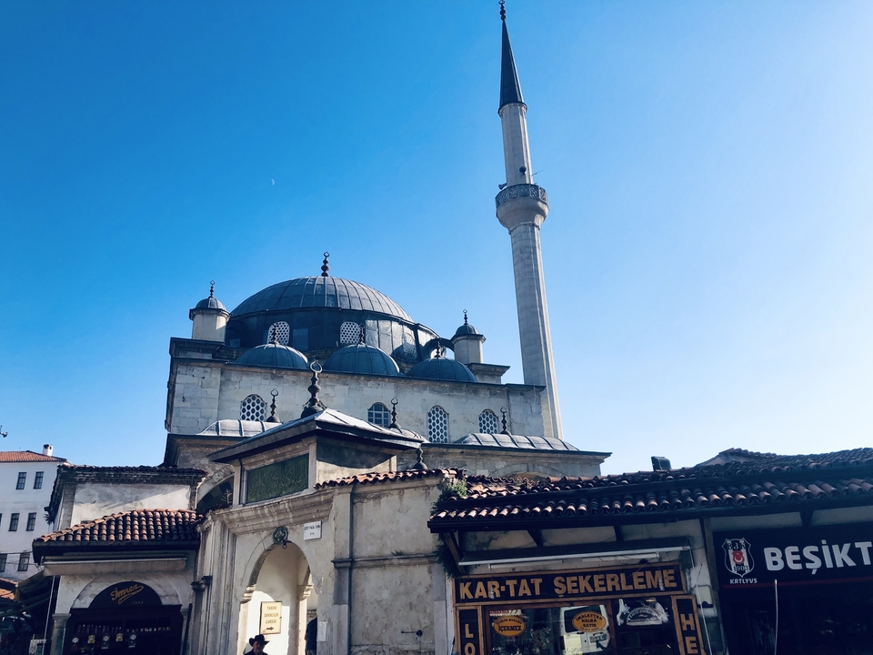 Mosquée avec un dôme entourée d'une zone de marché en plein jour.