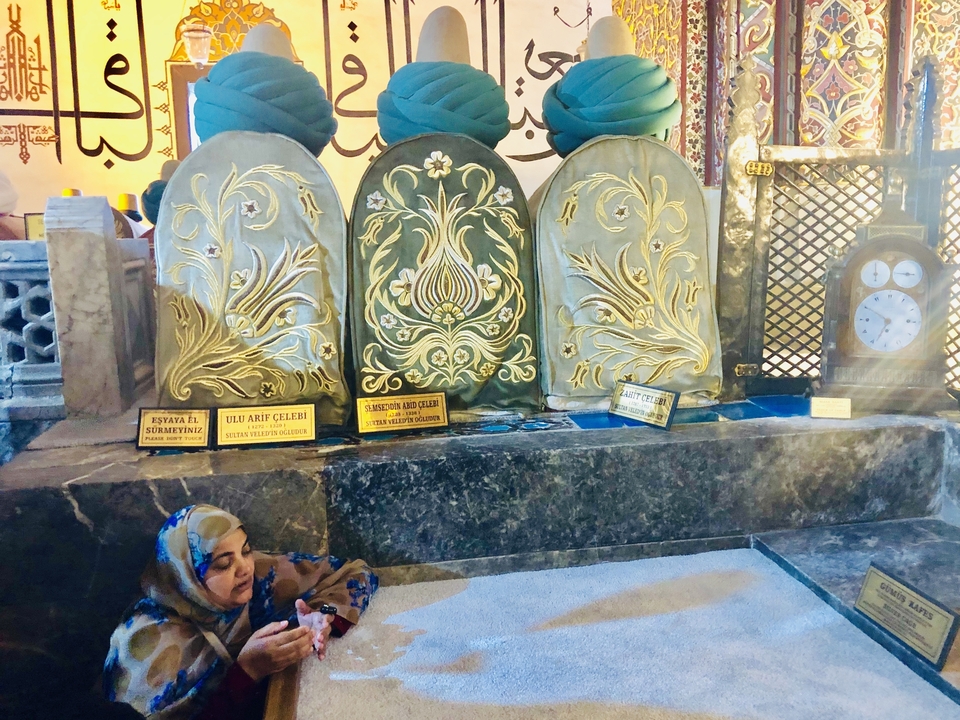 Femme près de pierres tombales ornées avec un motif doré