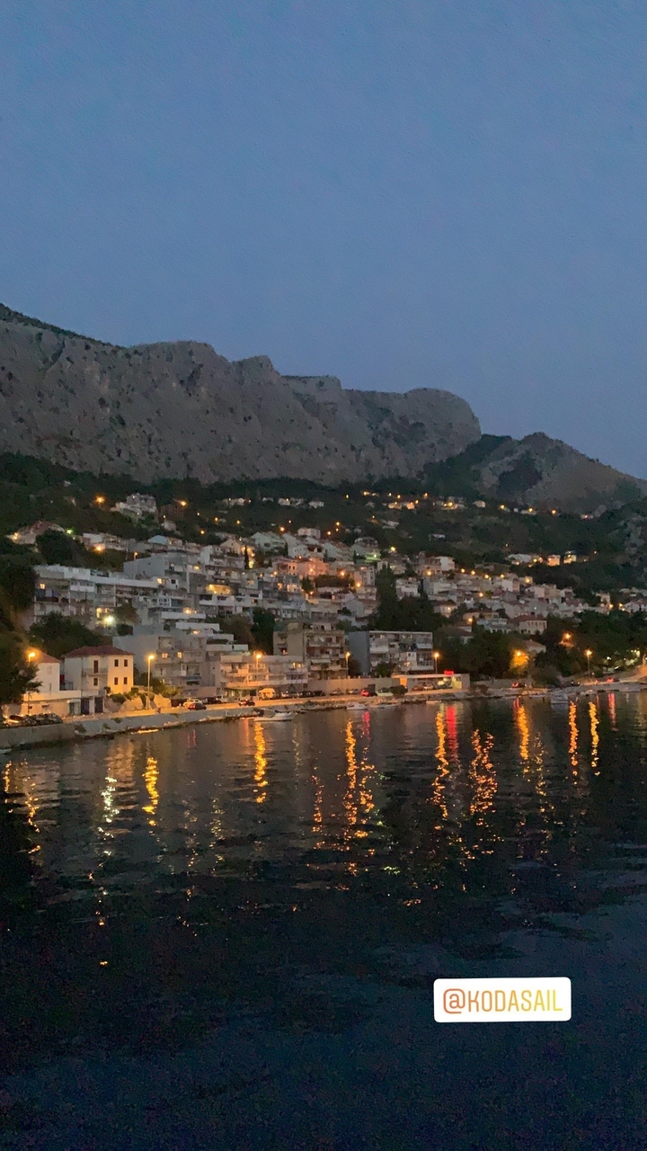 Une ville côtière illuminée la nuit.